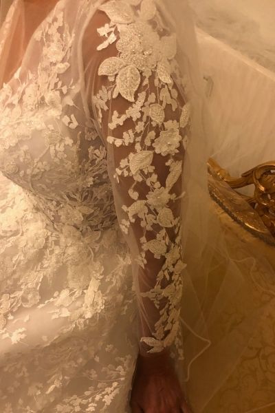 Hvid, langærmet brudekjole med nærbillede af blonder på ærmet