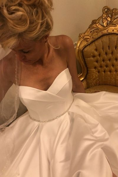 Stropløs brudekjole med nærbillede af top og glitterdetalje i taljen