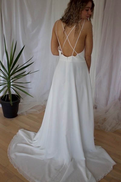 Hvid, enkel brudekjole med åben ryg og krydsende spaghettistropper - set bagfra